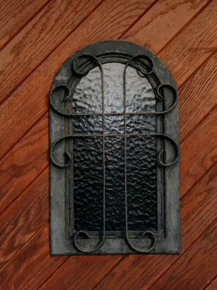 Eisenfenster auf rotem Holz